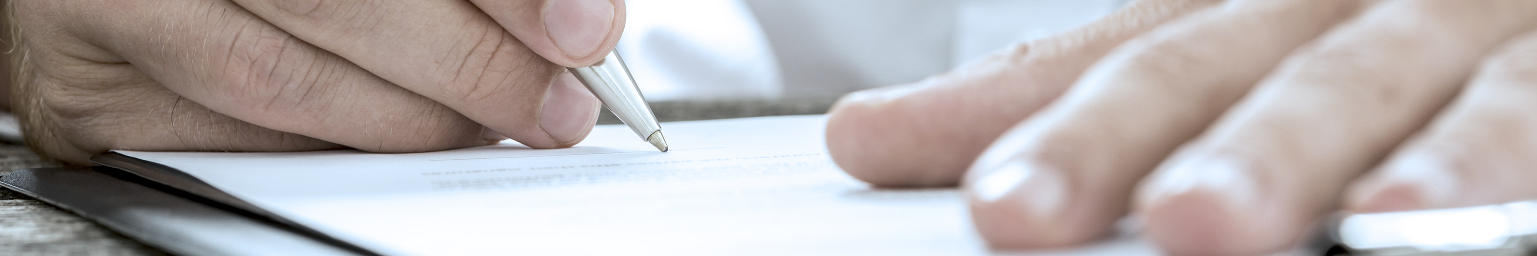 Low angle view of male hand signing contract or subscription
